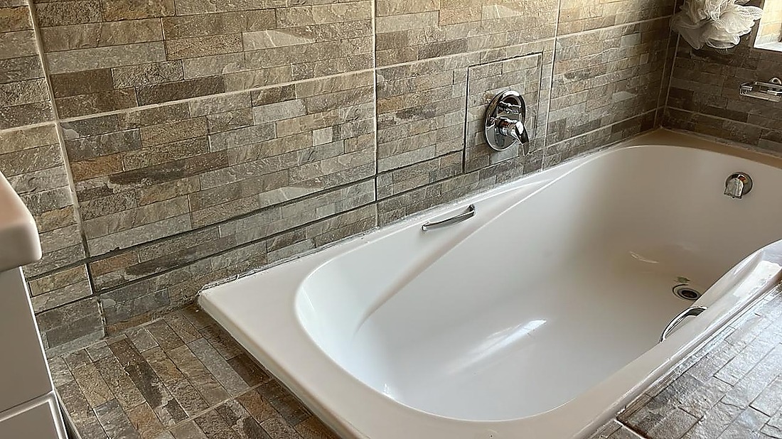 Bathroom renovation — stone tile bath and chrome fittings — Goudveld Plumbing Welkom
