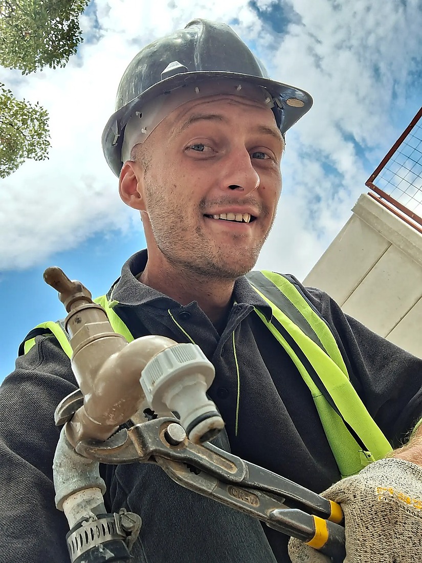 CJ Steyn — Founder of Goudveld Plumbing, Welkom, in hard hat and hi-vis vest on site